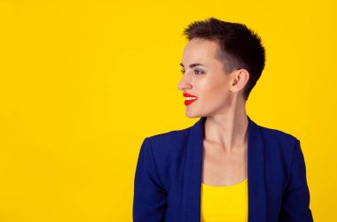 Dişlek söylemek hakkında gülümseyerek, sarı duvar arka plan üzerinde izole bir şey söyleyerek sağındaki isteyen profilde çok mutlu bir kadın portresi 