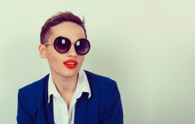 Güzel kadın portre resmi mavi elbise ve beyaz düğmeli gömlek üzerinde açık yeşil renkli izole poz güneş gözlüklü. Kısa saç ile beyaz kız modeli.