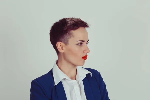 Side profile portrait of a pretty serious woman looking to the right side isolated on light green gray background wall Model in business clothing blue suit white buttoned shirt and short hair red lips
