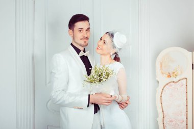 İçerik büyüleyici kadın ve adam ayakta ve sevgiyle kucaklayan düğün töreni için lüks kıyafetler içinde