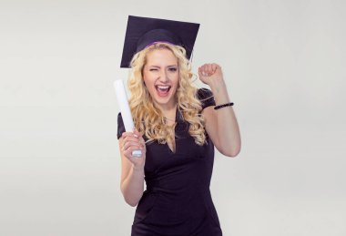 Gülümseyen kırpışan yanıp sönen bir yüksek lisans öğrencisi genç kadın diploma pompalama tutan şapkalı kutluyor izole başarı beyaz gri arka plan yumruklarıyla mutlu portre. Mezuniyet töreni gelecekteki kariyer kavramı