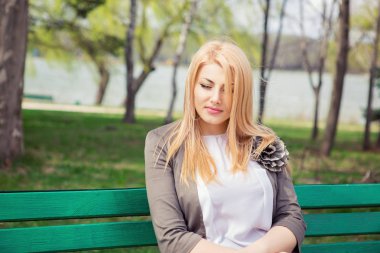 Düşünceli ve üzgün bir kız. Ne yazık ki yaz aylarında arka plan açık havada bir yeşil parkta bir bankta oturan düşünüyorum aşağı arayan bir kadın portresi. Yatay görüntü, karışık yarış Asya Rus modeli