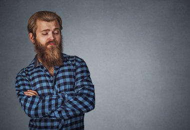 Kenarda boşaltmak isteyen şüpheli şüpheci adam. Mavi Kareli sakallı hippi erkek gömlek Isolated gri gri studio arka plan üzerinde kareli. Negatif yüz ifadesi, insan duygu, beden dili, tepki, tutum. Yatay atış.