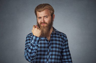 Adam veren parmak, parmak incir jest sıfır hiçbir şey olsun. Mavi ekose kareli gömlekli Isolated gri studio arka plan üzerinde sakallı hippi adam. Negatif yüz ifadesi, insani duyguları.