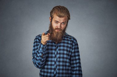 Sen kamera hareketi Hipster sakallı adam mavi ekose kareli gömlekli Isolated gri arka plan üzerinde parmak işaret kızgın genç sakallı adam portresi. Negatif yüz ifadesi, insani duyguları.