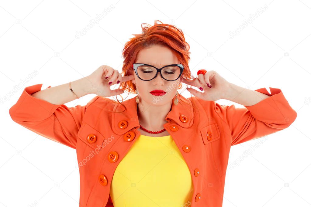 Headshot beautiful young woman covering both ears with her fingers hands eyes closed isolated white wall background. Caucasian person in yellow dress and coral necklace with red lipstick, redhead hair