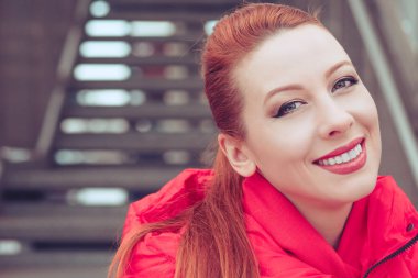 Açık havada gülümseyen Kızıl saçlı kadın.