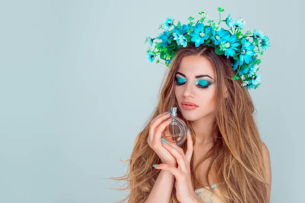 Mujer con diadema floral oliendo un perfume — Foto de Stock