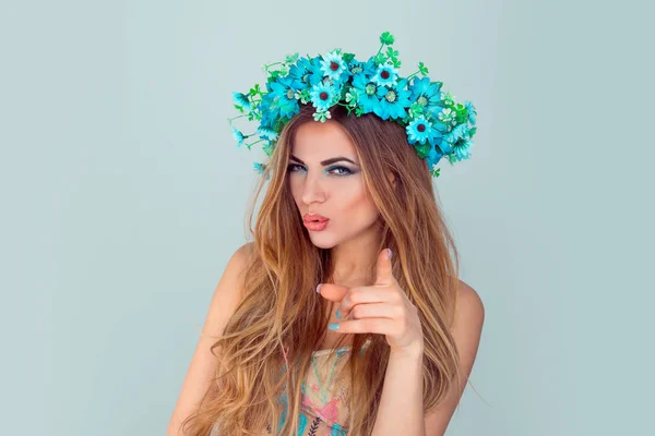 Vrouw met bloemen kroon op het hoofd uitziende wijzend op u — Stockfoto