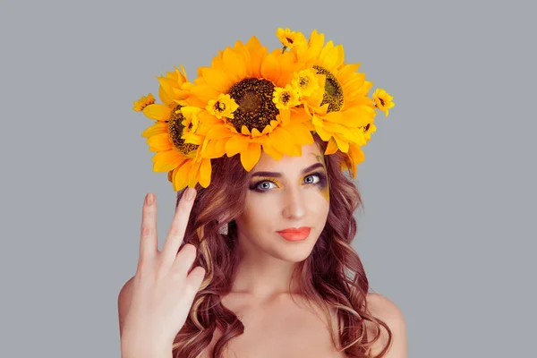 woman with floral headband is showing peace sign