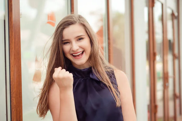 We can do it. Closeup portrait happy young woman happy exults pumping fist ecstatic isolated outdoors city store background. Power strength concept. Facial expression emotions feelings body language