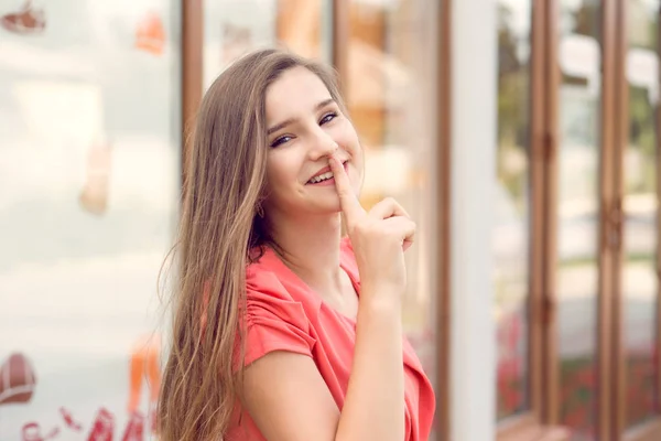 Shh. Woman smiling asking for silence secrecy with finger on lips hush hand gesture office store outdoors background Pretty girl placing fingers on lips sign symbol. Positive emotion facial expression