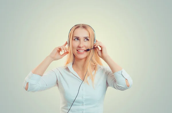 Asian agent woman holding headset looking up to copy space smiling happy. Caucasian Business person in white formal shirt, long blonde hair girl isolated on light green yellow studio background