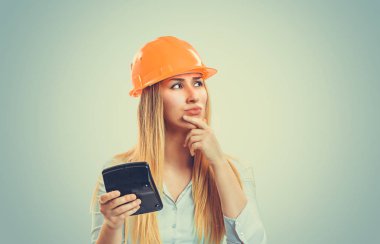 Mimar düşünüyorum. Portre sarı ile ciddi genç inşaat kadın portre kap durulması durum el çene izole hesap makinesi yeşil arka plana olumlu duygu dayanabiliyor seyir planlama