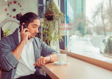 adam akıllı telefon tarafından konuşan kol saati kontrol saat bakıyor