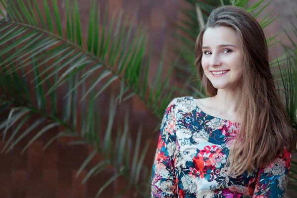 Kadın gülümseyen mutlu görünümlü, arka planda Fern ile