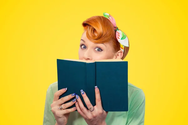 Schockiertes Pinup-Mädchen versteckt sich hinter einem Buch — Stockfoto