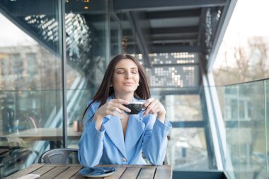 Balkonda çay içen bir kadın.