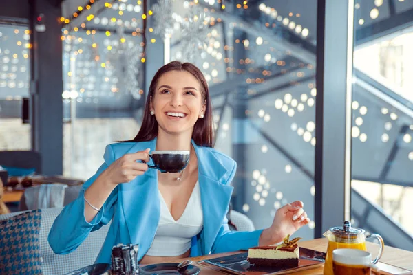 Mujer sentada en el balcón de la cafetería sosteniendo la taza de té caliente . —  Fotos de Stock
