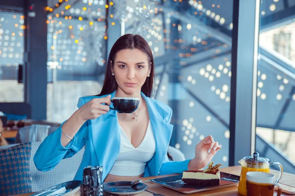 Женщина ест десерт и пьет кофе — стоковое фото