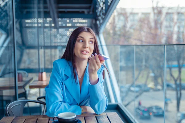 Mujer usando el reconocimiento de voz del teléfono en un café —  Fotos de Stock