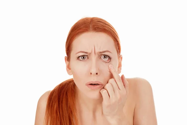 Mujer mirando sus ojos aislados sobre un fondo blanco puro — Foto de Stock