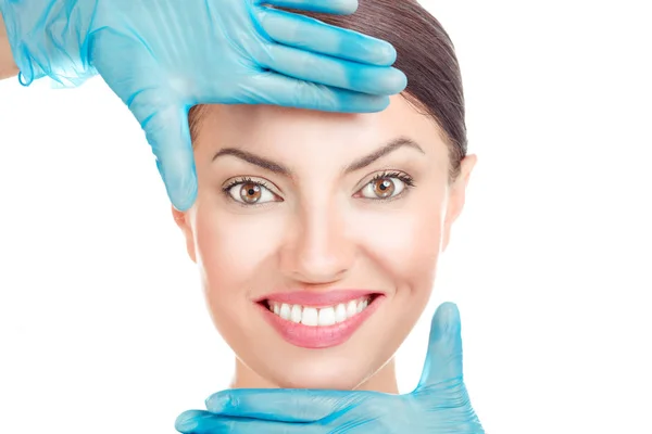 Médico mano en guantes dando forma a un marco alrededor de la cara de una chica —  Fotos de Stock