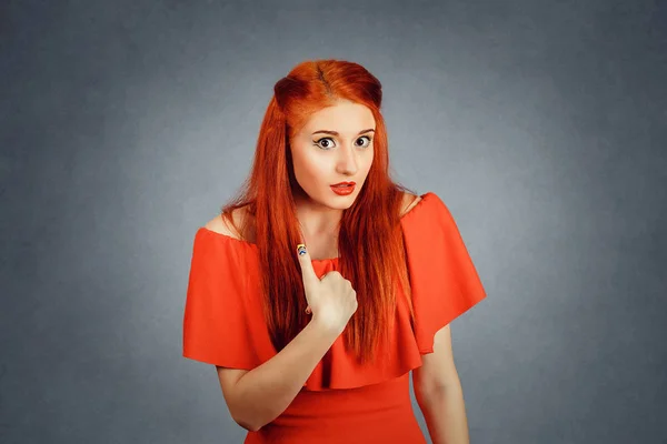 Schöne Frau blickt mit dem Finger auf sich selbst, roter Hintergrund — Stockfoto