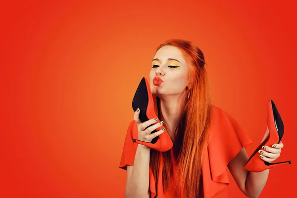 サイドプロファイル女性は靴にキス 女性はハイヒールシューズのコンセプトが大好きです 赤い壁の背景に隔離された美しい若い幸せな女性モデル — ストック写真