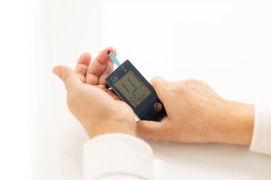 Bir kişinin elleri, kadın ya da erkek kendini kontrol ediyor, diyabet ve kan şekeri monitörü dijital basınç göstergesi, Glukometre. Sağlık ve Tıp Konsepti. Kan şekeri değeri 11 çok yüksek.