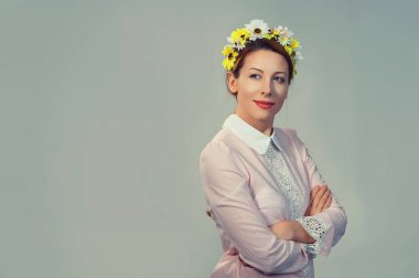 Yakın plan portre, kendine güvenen, başarılı, ayçiçekleri desenli çiçek desenli güzel ve çekici bir kadın. Gri arka planda izole edilmiş, elleri çapraz moda kızı ile kameraya bakıyor.