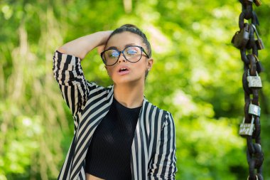 Ben seksiyim ve bunu biliyorum. Yakın plan portresi güzel esmer kadın kilitleri olan bir zincirin yanındaki yeşil doğa arka plan duvarında izole görünüyor. Pozitif duygu yüz ifadesi