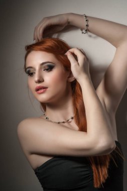 Doğal ciltli kadın yüzünün güzel portresi, eller başının üstünde ve saçlar kendini kucaklıyor izole edilmiş açık bej rengi, gri arka plan ve kopya alanı.