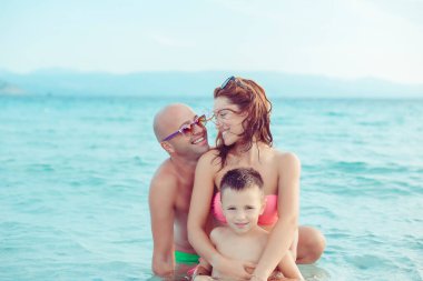 Mutlu, genç bir aile, tatillerde denizde, güzel plajlarda, açık havada eğleniyor.