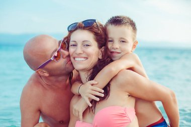 Mutlu, genç bir aile, tatillerde denizde, güzel plajlarda, açık havada eğleniyor.