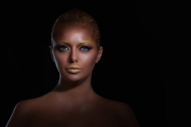 Güzellik. Yakından bakınca koyu tenli, güzel, seksi kadın modeli makyajlı, yeşil, gri gözlü, kameralı, çıplak omuzlu, yüzü izole siyah arka planda..