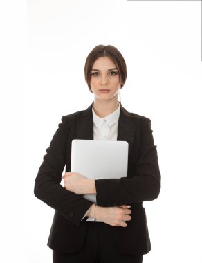 Güzel bir kadının kişisel bilgisayarı tutarken, elinde dizüstü bilgisayarla kameraya bakarken, resmi siyah takım elbise ve beyaz gömlekli saf beyaz arka planda izole edilmiş bir kız portresi.