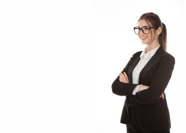 Güzel bir kadının, gülümseyen, kolları çaprazlanmış, kendine güvenen, siyah takım elbiseli, gözlüklü, beyaz gömlekli güzel bir iş kadını portresi.