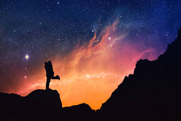 Silhouette of a Couple kissing on a starry night, Falling in Love at Valentine's Day, dating, love romance concept. Dramatic scenery.