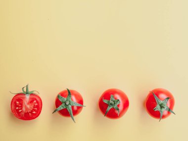 Sağlıklı ve diyet konsepti. Üç kirazlı domates ve bir yarısı şeftali rengi stüdyo arka planında, fotokopi alanı ile izole edilmiş. Düz yatış, yukarıdan görünüm.