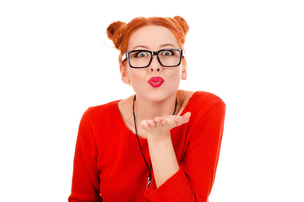 Closeup portrait beautiful attractive young happy woman girlfriend puckering up, sending blowing kiss in red shirt isolated on pure white background. Human face expression emotion attitude reaction