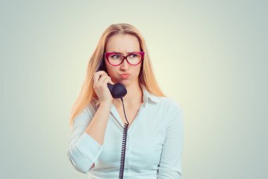 Ciddi huysuz, hayal kırıklığına uğramış bir kadın. Hoş olmayan bir telefon görüşmesi yapıyor. Öfkeyle dudak büküyor.