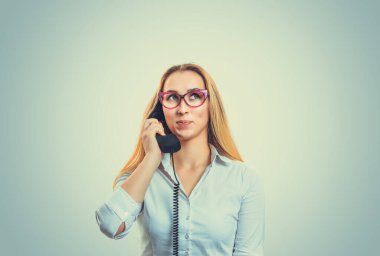 Telefonda konuşan, kafası karışmış, gülümseyen, hayal kuran, açık yeşil arka planda izole edilmiş, telif hakkı olan, düşünceli, düşünceli bir kadın. Pozitif yüz ifadesi, duygusal tepki tavrı