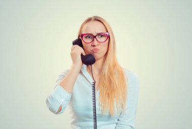 Yanlış anlaşılma ve uzak bir çağrı. Telefonda konuşan üzgün genç bir kadın açık yeşil arka planda izole edilmiş arama yüzünden hayal kırıklığına uğramış. Kız sabit hattan hayal kırıklığına uğramış arka plan müziği duyuyor.