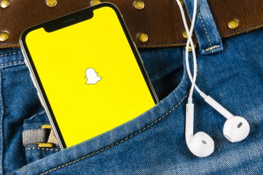 Sankt-Petersburg, Rusya, 14 Nisan 2018: Snapchat uygulama simgesi üzerinde Apple iphone X smartphone ekran yakın çekim kot pantolon cebinde. Snapchat app simgesi. Sosyal medya simge. Sosyal ağ