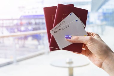 Pasaport tutarak ve yatılı güzel kadın el closeup geçmek bilet havaalanında terminal. Seyahat ve tatil kavramı. Terminal salonu. Boş alanı. Kopya alanı.