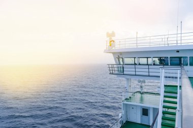 Cruise gemi beyaz kabin büyük pencereler ile. Çalışan köprü cruise liner kanat. Radar ve navigasyon sistemi ile mavi bir gökyüzü beyaz yolcu gemisinde. Tamam. Okyanusu günbatımı arka plan.