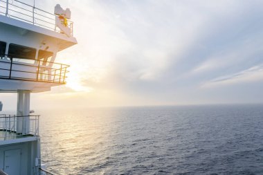 Cruise gemi beyaz kabin büyük pencereler ile. Çalışan köprü cruise liner kanat. Radar ve navigasyon sistemi ile mavi bir gökyüzü beyaz yolcu gemisinde. Tamam. Okyanusu günbatımı arka plan.
