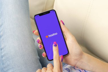 Sankt-Petersburg, Russia, May 30, 2018: Badoo application icon on Apple iPhone X screen in woman hands. Badoo app icon. Badoo is an online social media network. Social media app clipart