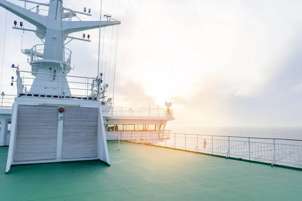 Cruise ship white cabin with big windows. Wing of running bridge of cruise liner. White cruise ship on a blue sky with radar and navigation system. Captain\'s cabin. Ocean sunset background.